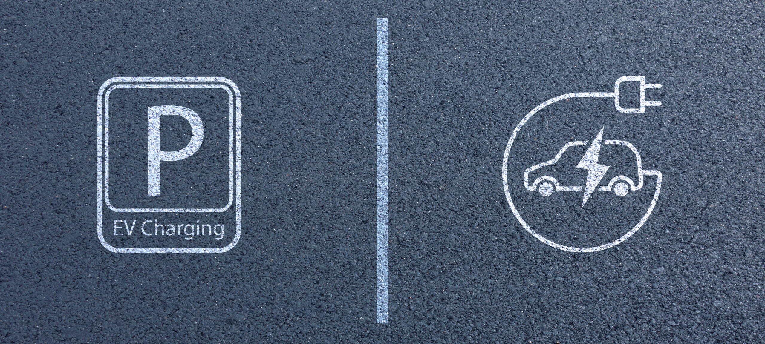 Electric Vehicle Charging Station Sign on Asphalt Background in public area, with parking spaces and road markings denoting charging bays Parkplatzmarkierung für Ladestationen