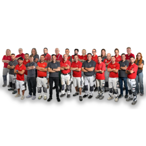 maler-bothe-start-ueberuns Team des Malerbetriebs Bothe vor dem Firmengebäude. Ein freundliches Team in Arbeitskleidung, bereit für Maler- und Renovierungsarbeiten im Harz. Im Vordergrund steht ein Hund. Keywords: Malerbetrieb, Team, Harz, freundlicher Service