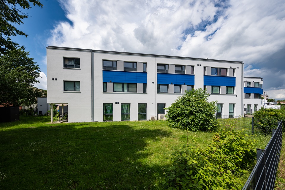 Ein Gerüst vor gelbem Haus - hier wird die Fassade neu gemacht und die Wärmedämmung nachgezogen. So kann man das Raumklima verbessern und Energiekosten reduzieren!